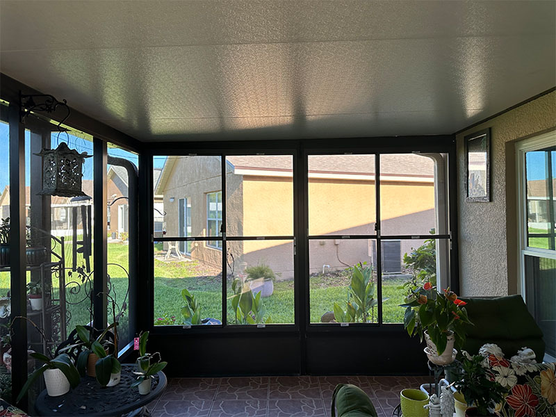 View from inside screen room looking out windows.