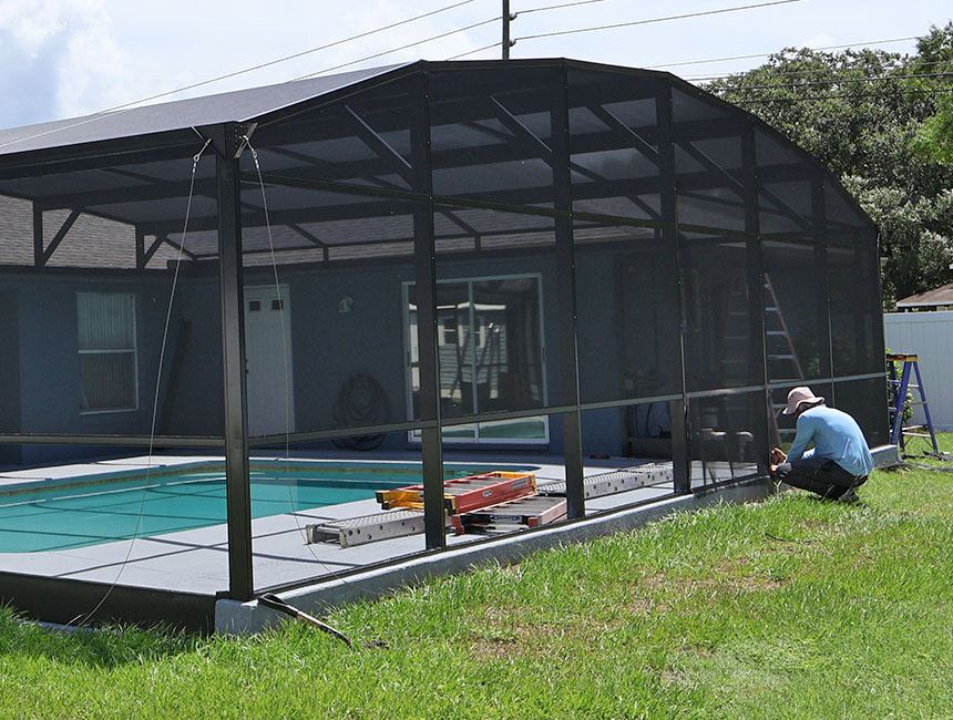 MD Construction worker installing a screen on a pool enclosure. Front lanai installation review. Screen enclosures. Screening a lanai. Screen enclosures near me. Sunrooms Orlando Florida. Poop Lanai. Sunroom Orlando fl. Lanai Patio enclosure. Patio enclosure suppliers. Patio cover with screen. Pool enclosure florida. patio cover screen. florida screened in porch. screen patio covers. pool screen enclosures florida. screen pool enclosures florida. patio screen enclosures near me. florida porches