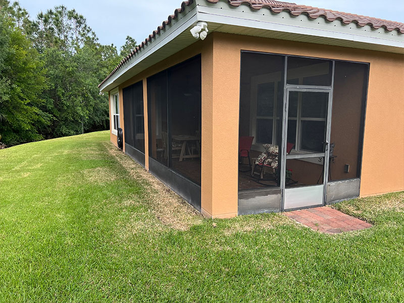Side view with door of rear lanai in Poinciana, Florida before transformation