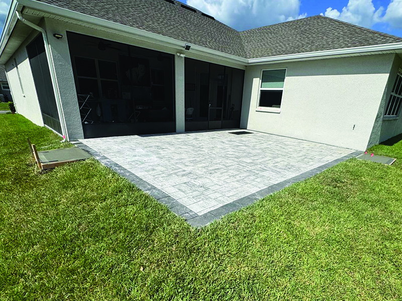 new-concrete-installed-outside-of-pavers-in-lakeland-by-md-construction Full view of new concrete door pad installed by MD Construction outside the pavers for the screen room.